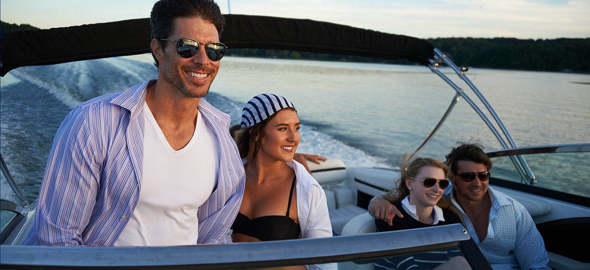 Two Couples on Cobalt Boat Smiling with Wind in their Hair