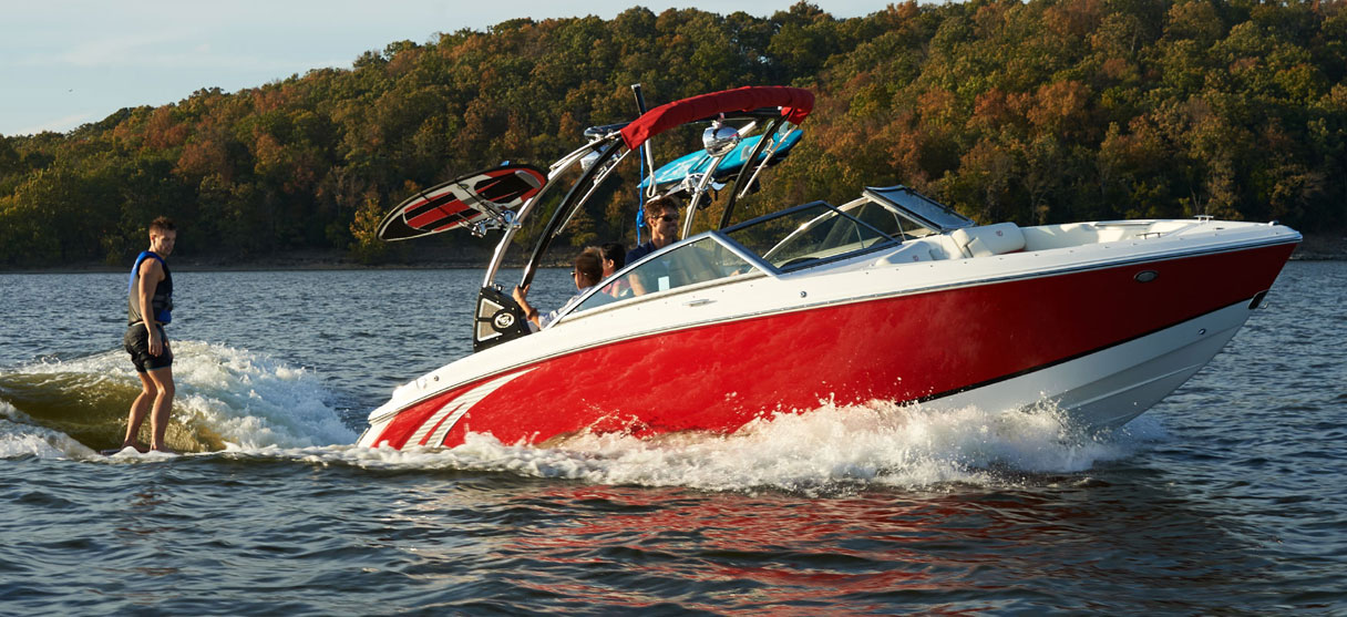 Cobalt Surf Series R3 in Knockout Red with Surfer Riding Wave Behind Boat
