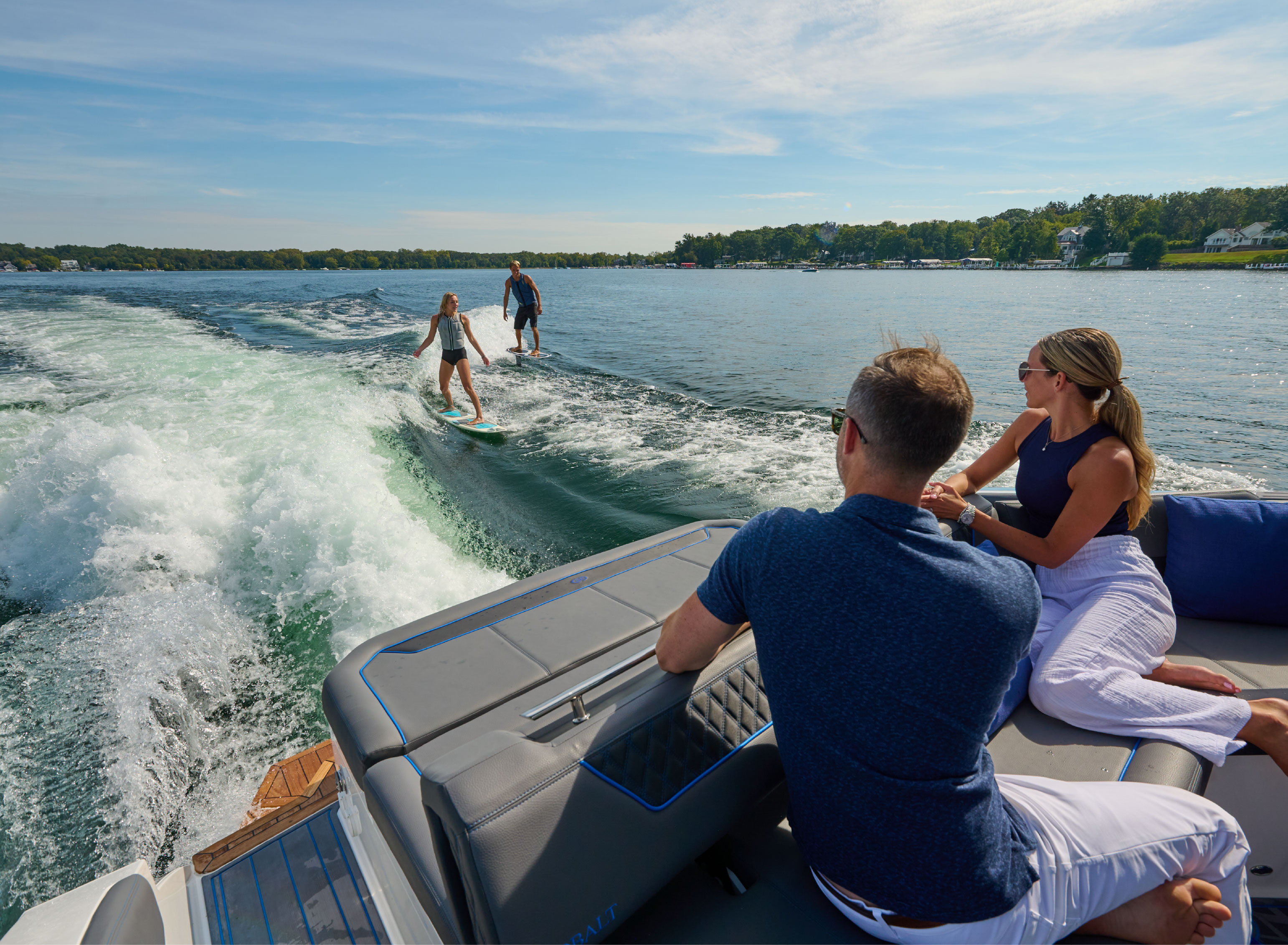 People watching surfers from boat