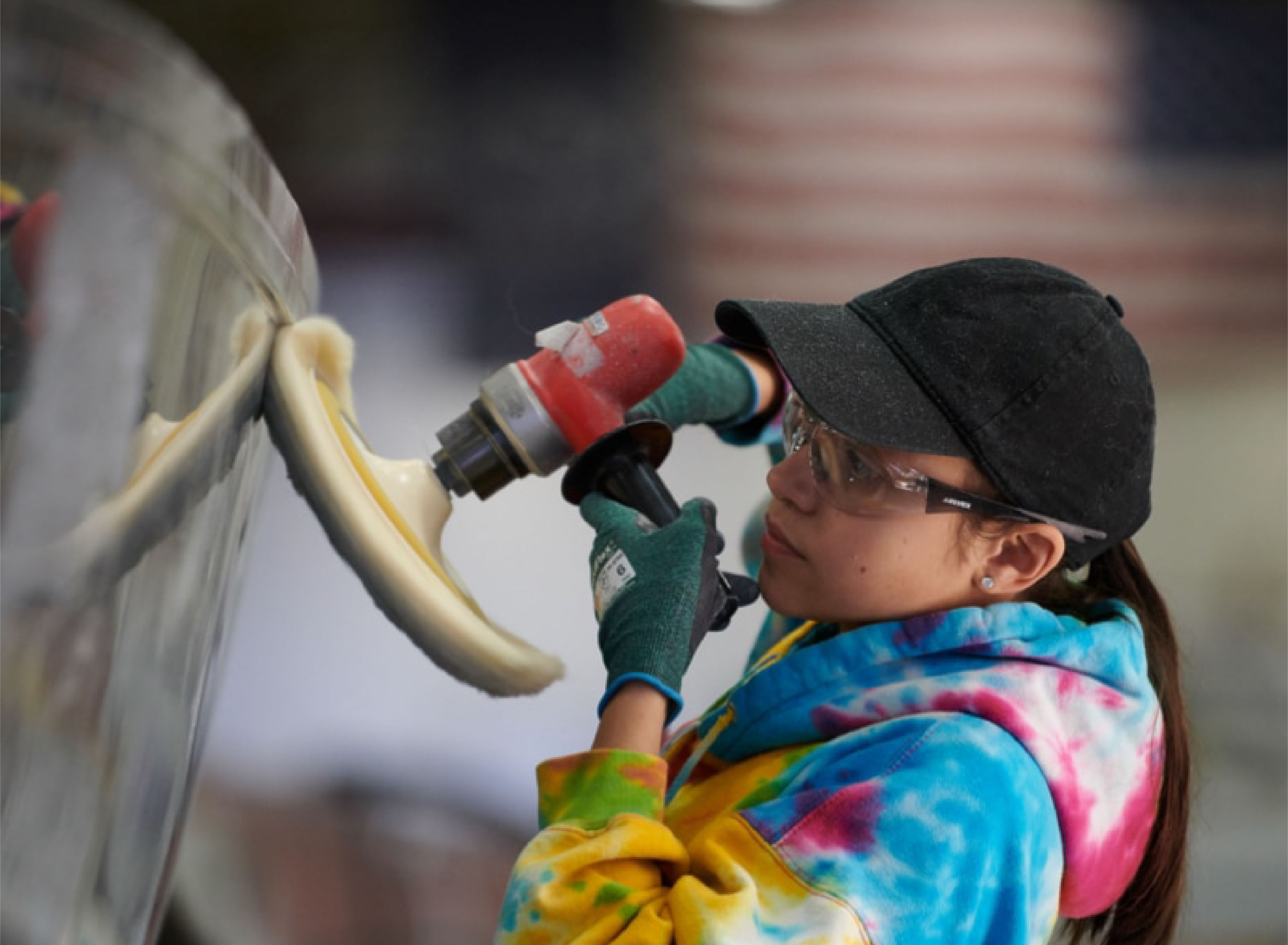 a person in tie dye drilling into a boat
