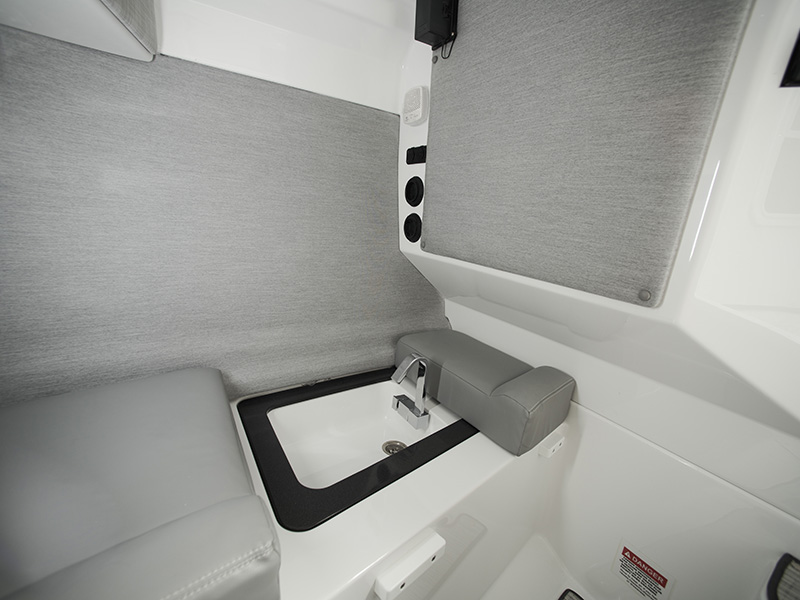 Cobalt A29 day cabin optional sink with chrome faucet and dark basin installed in the light gray upholstered cabin interior