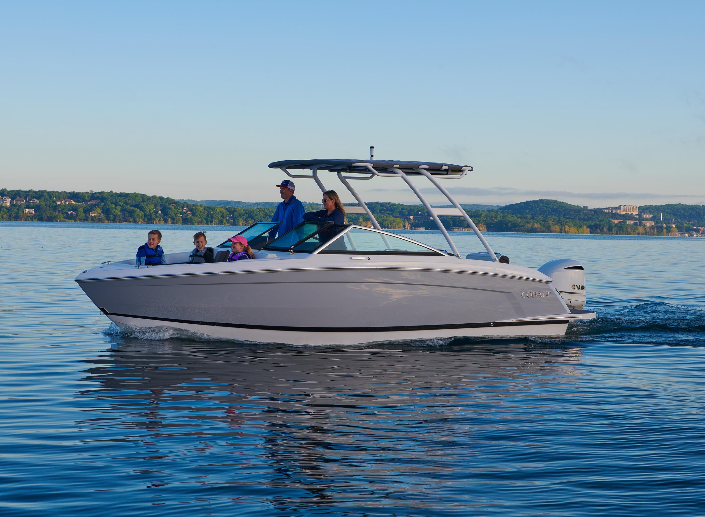 Cobalt boat cruising along a scenic coastline with passengers enjoying the open water coastal adventure experience together