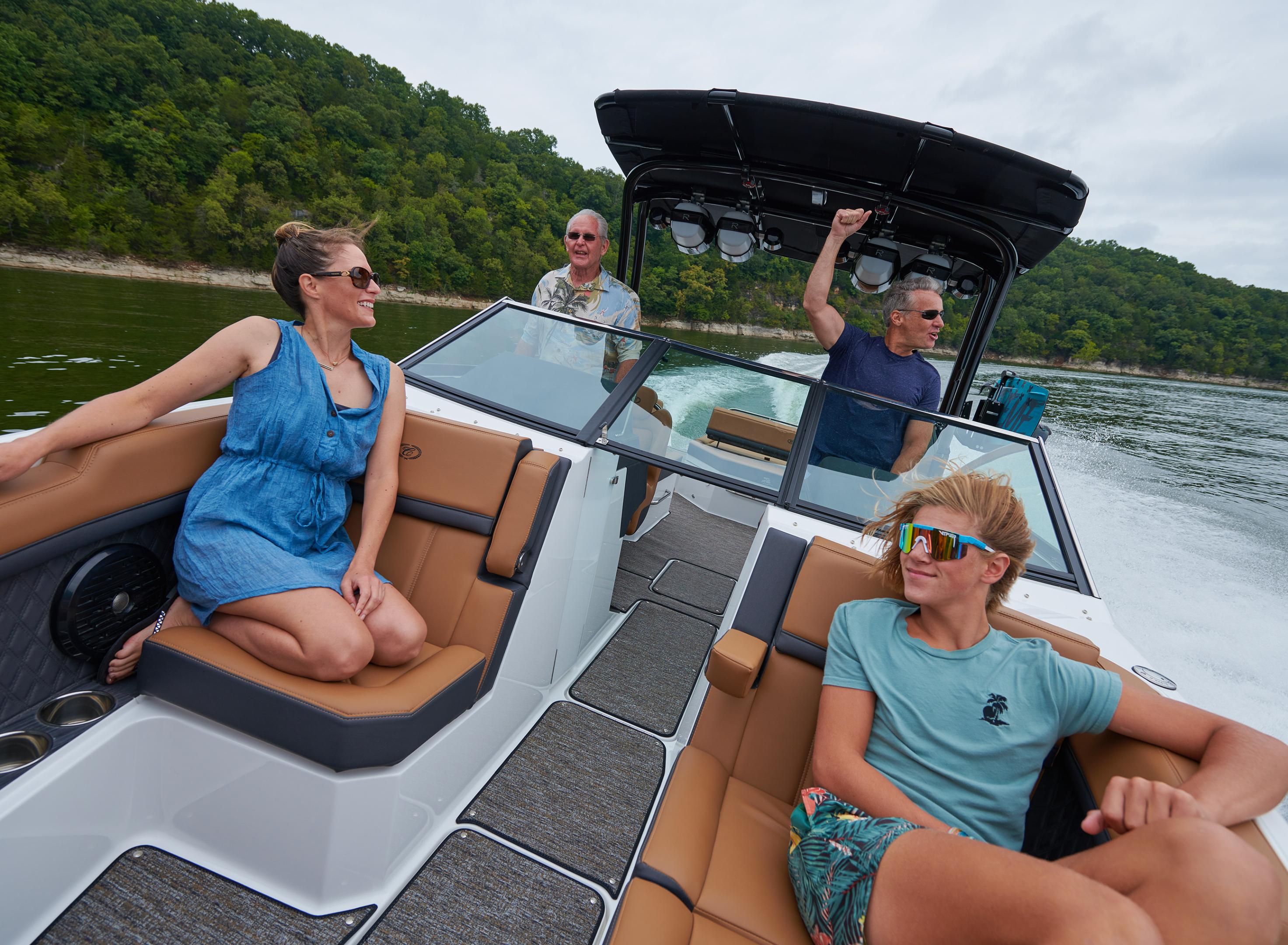 Cobalt boat and passengers on an open water performance cruising journey at speed across beautiful coastal scenery