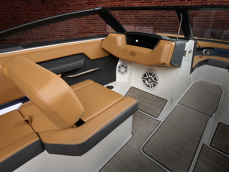 Cobalt CS22 convertible passenger seat with tan leather upholstery, integrated console speakers, and dark-contrast floor mat