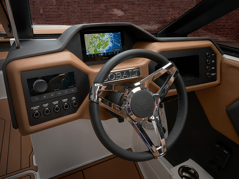 Cobalt CS23 redesigned helm dash with Garmin touchscreen display, Fusion audio, chrome Cobalt steering wheel, and tan leather trim