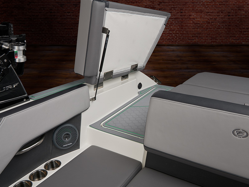 Cobalt CS23 Surf aft walk-thru and filler area with open storage hatch visible and gray upholstered seating in studio lighting