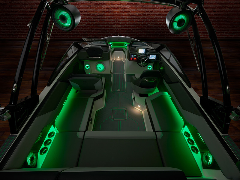 Cobalt CS23 Surf full interior with vivid green LED accent lighting illuminating all seating areas, speakers, and deck features at night