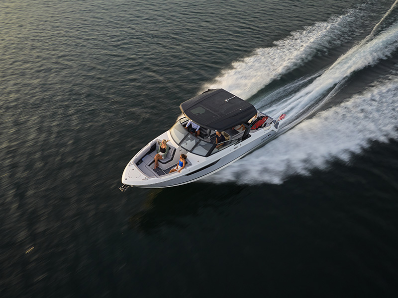 Cobalt R31 Surf aerial drone view with black arch hardtop at speed on open water with passengers aboard