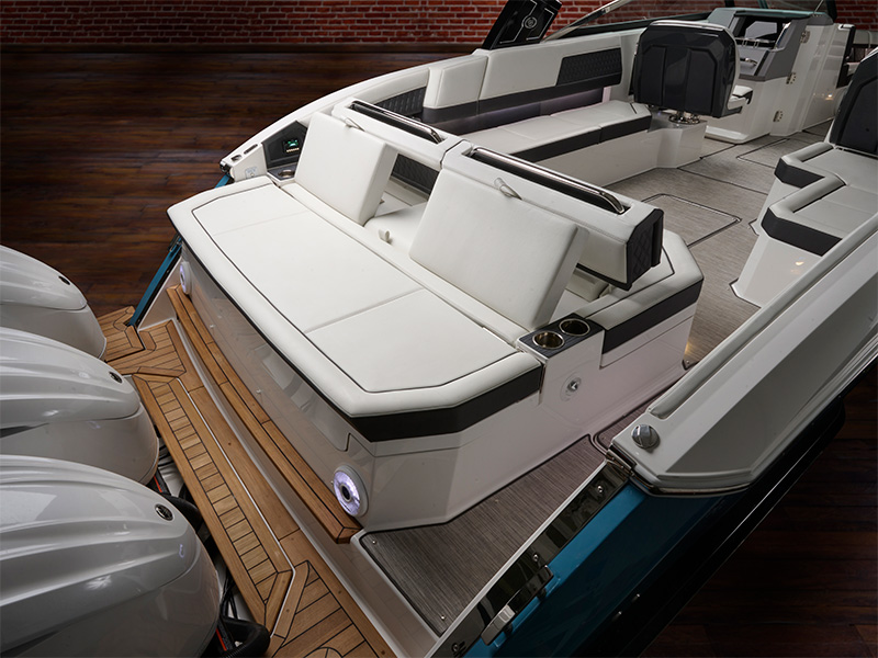 Cobalt R33 Coastal aft-facing rumble seat with white upholstered lounge seating flanked by Yamaha outboard engines