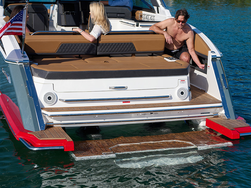 Cobalt R33 Sterndrive hydraulic swim platform lowered to water with couple relaxing on aft deck
