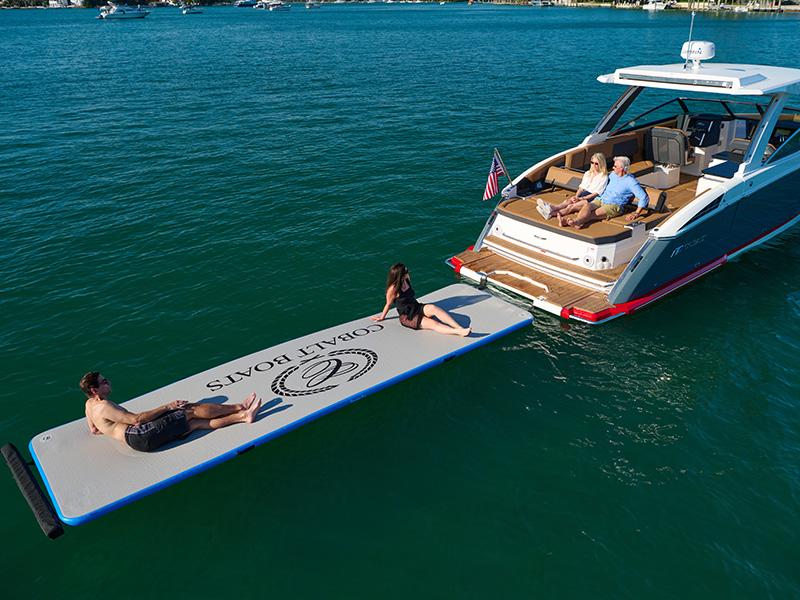 Cobalt R33 Sterndrive Splash and Stow with branded inflatable float mat deployed off stern on turquoise water