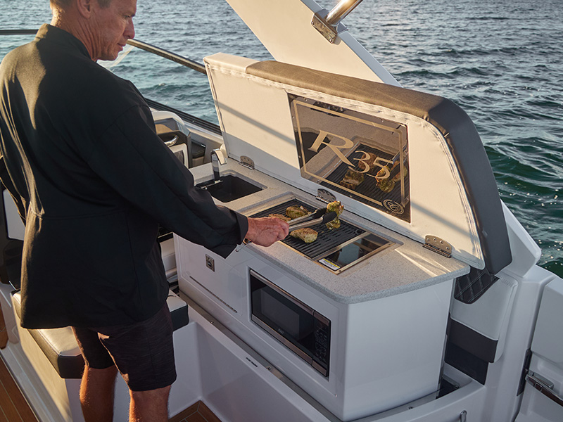 Cobalt R35 Coastal outboard autodeploy galley with built-in grill and microwave in use on open water