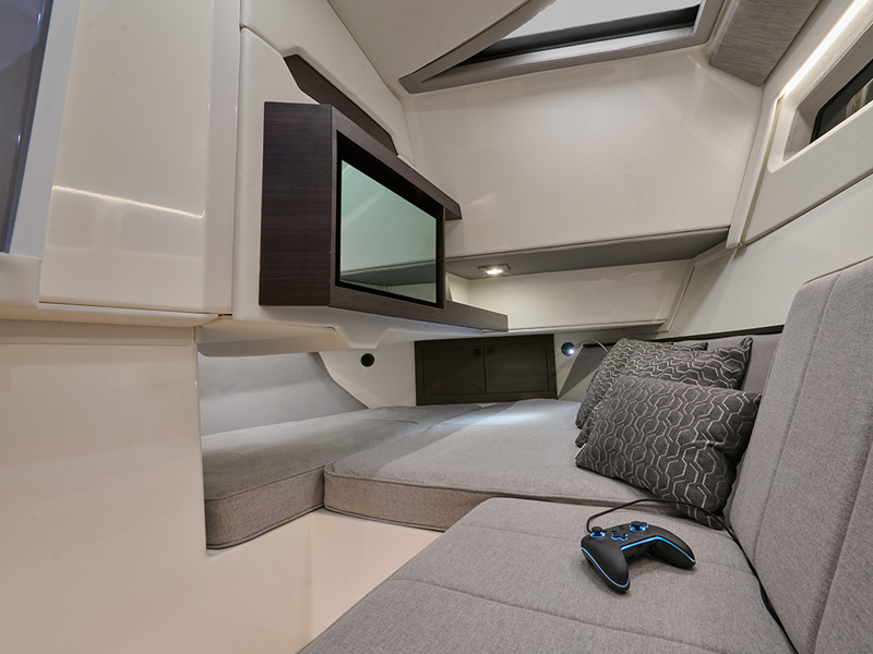 Cobalt R35 Surf cabin interior with flat-screen TV, plush upholstered berth, accent pillows, and entertainment amenities