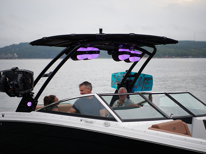 Cobalt R8 Sterndrive stainless steel windshield trim with illuminated surf tower and passengers aboard at dusk