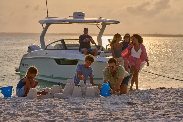 people on shore infront of a boat