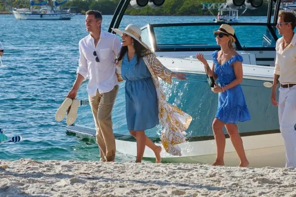 people on shore in front of a boat