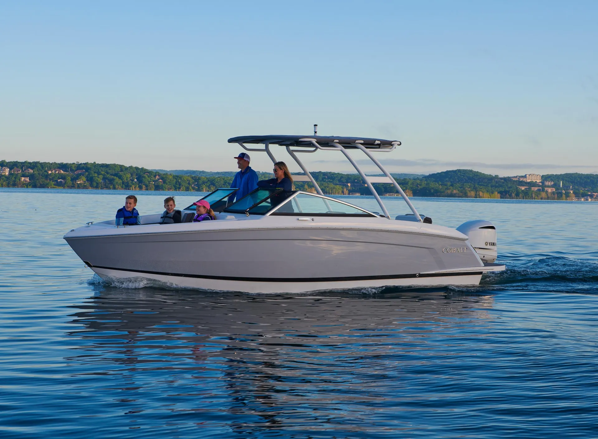 Cobalt boat cruising along a scenic coastline with passengers enjoying the open water coastal adventure experience together